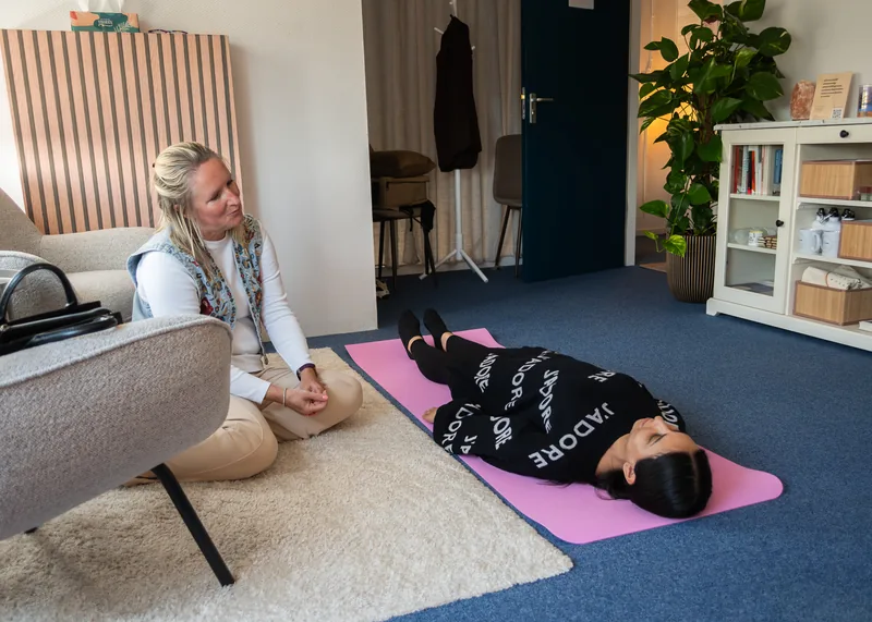 Corine begeleidt een ontspanningsoefening in haar praktijk.